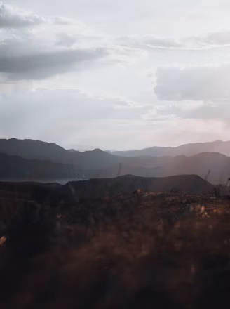 silhouette of mountains under cloudy sky during daytime