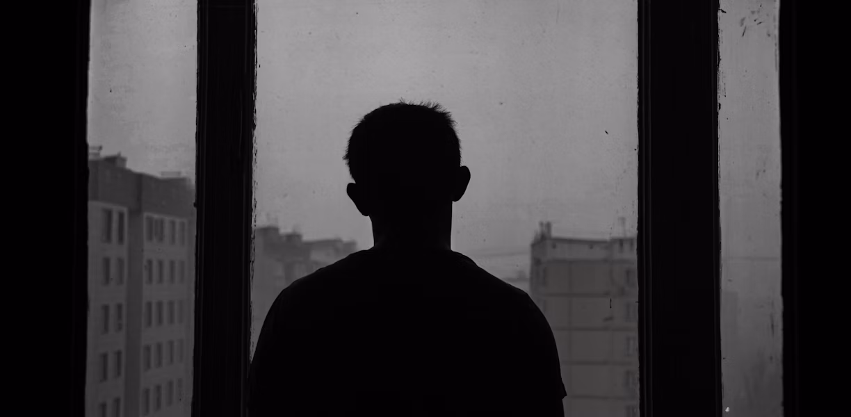 silhouette of man standing near window