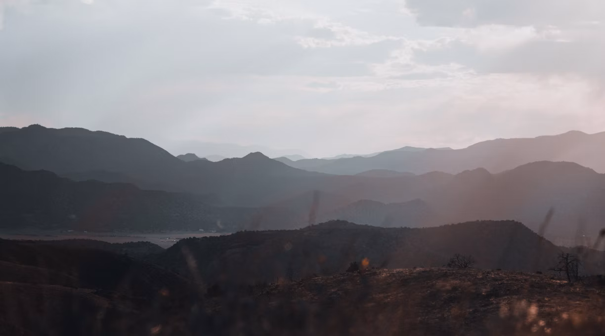 silhouette of mountains under cloudy sky during daytime